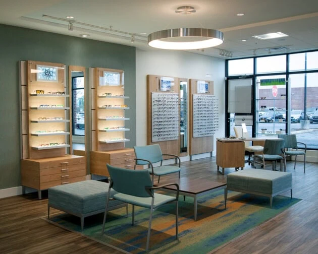 A seating area with displays of glasses on the wall.